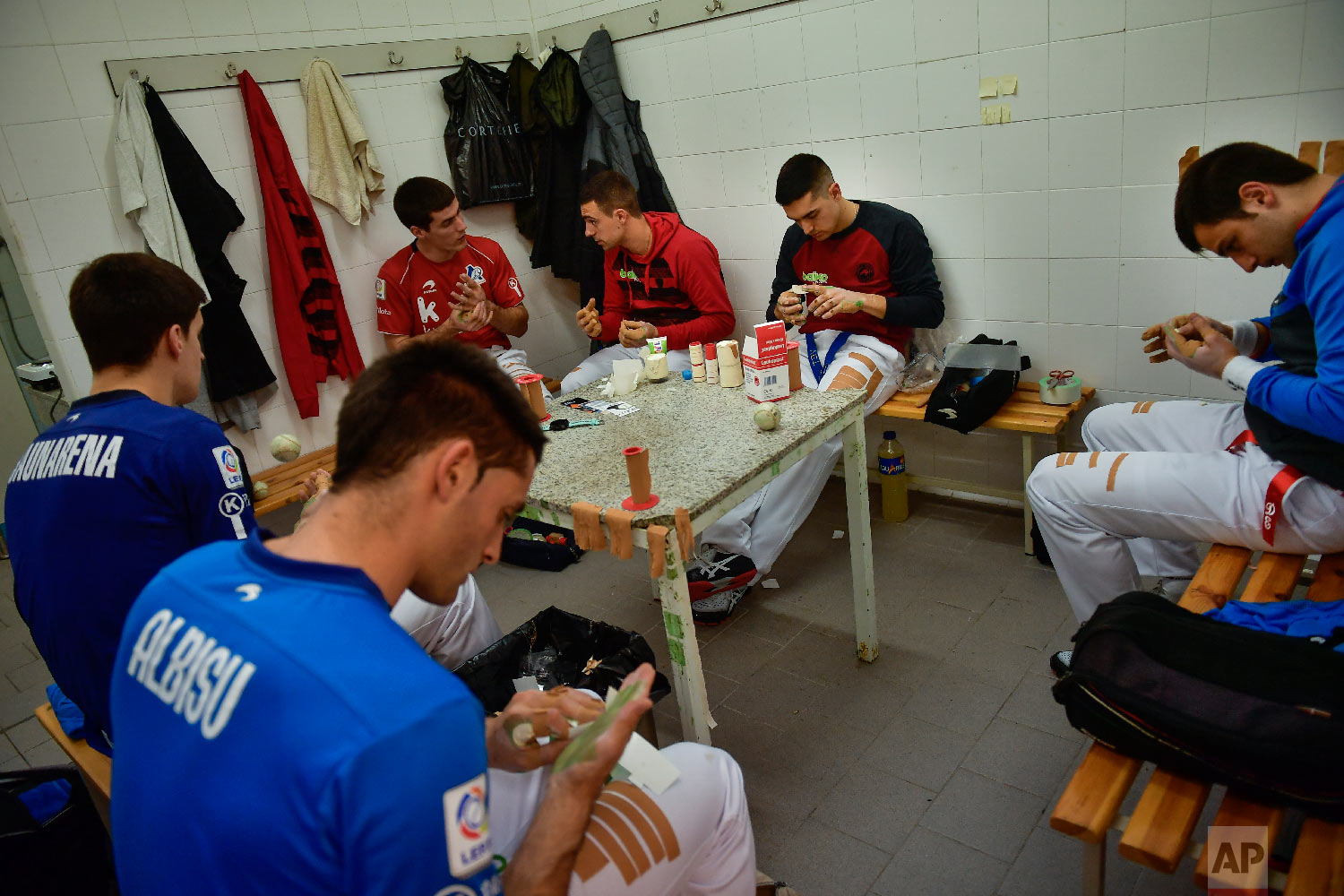 Players of Basque Ball known as "pelotari", use tape to protect their hands ahead of a match at Labrit court or fronton, in Pamplona, northern Spain on March 1, 2019. (AP Photo/Alvaro Barrientos)