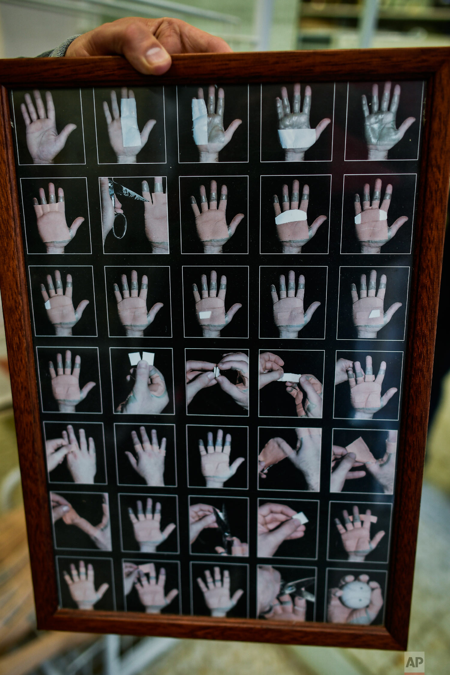 A poster with photographs shows how to protect the hands to practice the Basque Ball or "pelota vasca", at a store in Pamplona, Spain on Feb. 28, 2019. (AP Photo/Alvaro Barrientos)