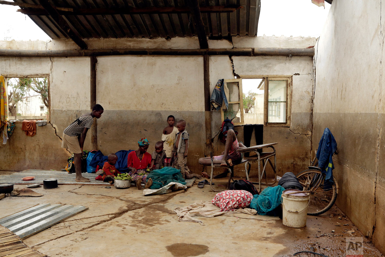 Displaced families rest inside a damaged classroom in Buzi district, 200 kilometers (120 miles) outside Beira, Mozambique, on Saturday, March 23, 2019. (AP Photo/Themba Hadebe)