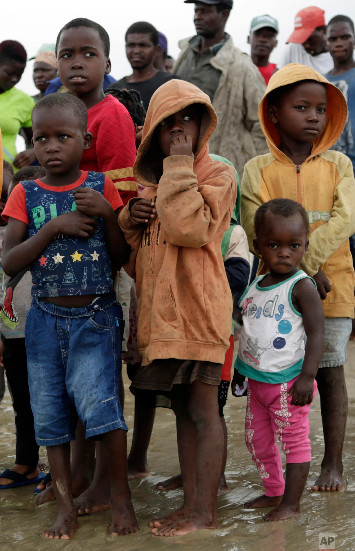 Children wait as their parents disembark from a boat after being rescued from a flooded area of Buzi district, 200 kilometers (120 miles) outside Beira, Mozambique, on Saturday, March 23, 2019. (AP Photo/Themba Hadebe)