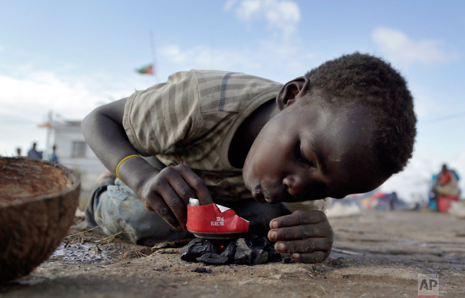 A young boy makes fire as he plays in Buzi district, 200 kilometers (120 miles) outside Beira, Mozambique, on Saturday, March 23, 2019. (AP Photo/Themba Hadebe)