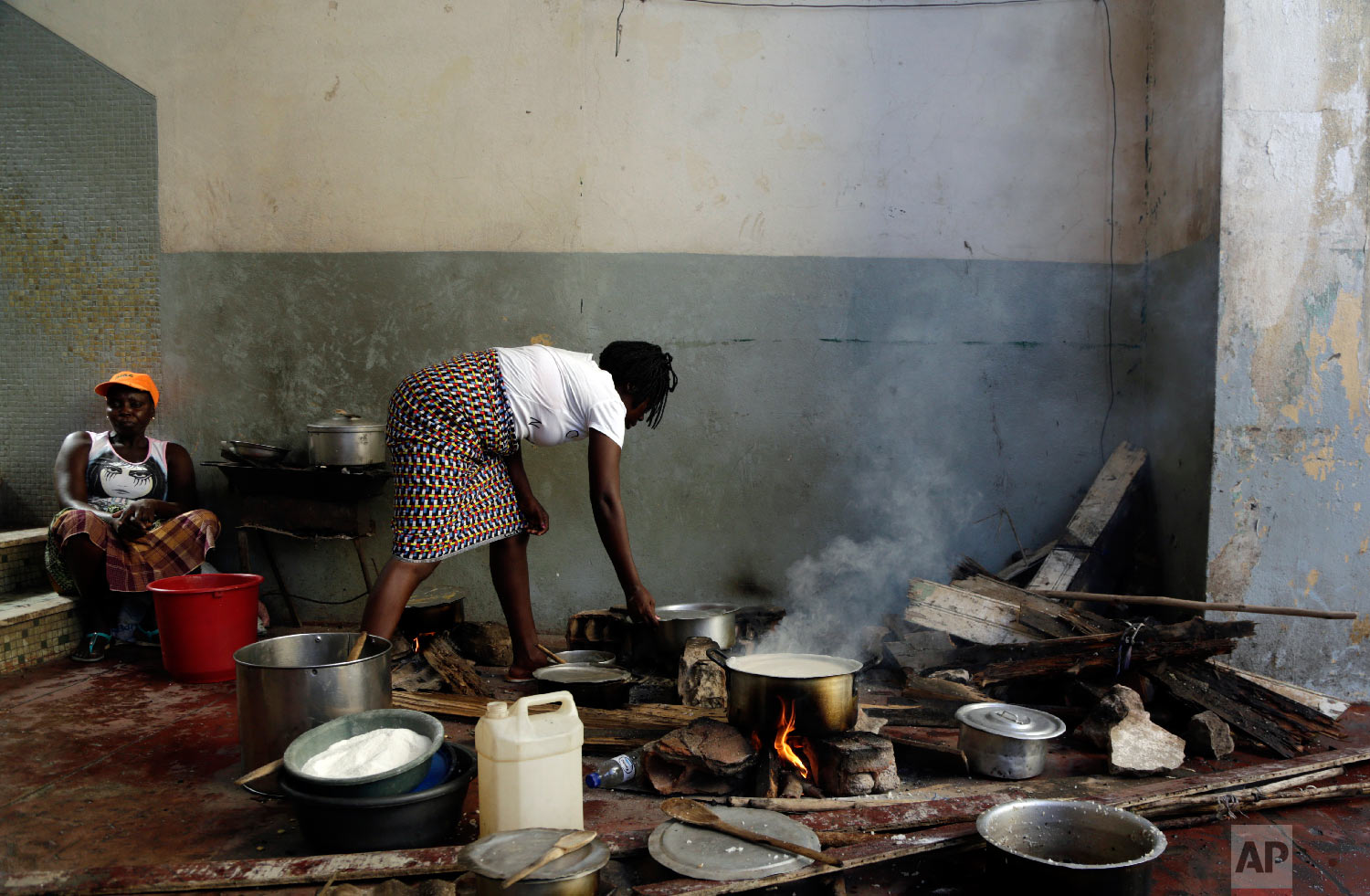 A woman cooks on the floor at a displacement centre in Beira, Mozambique, Friday, March 22, 2019. (AP Photo/Themba Hadebe)
