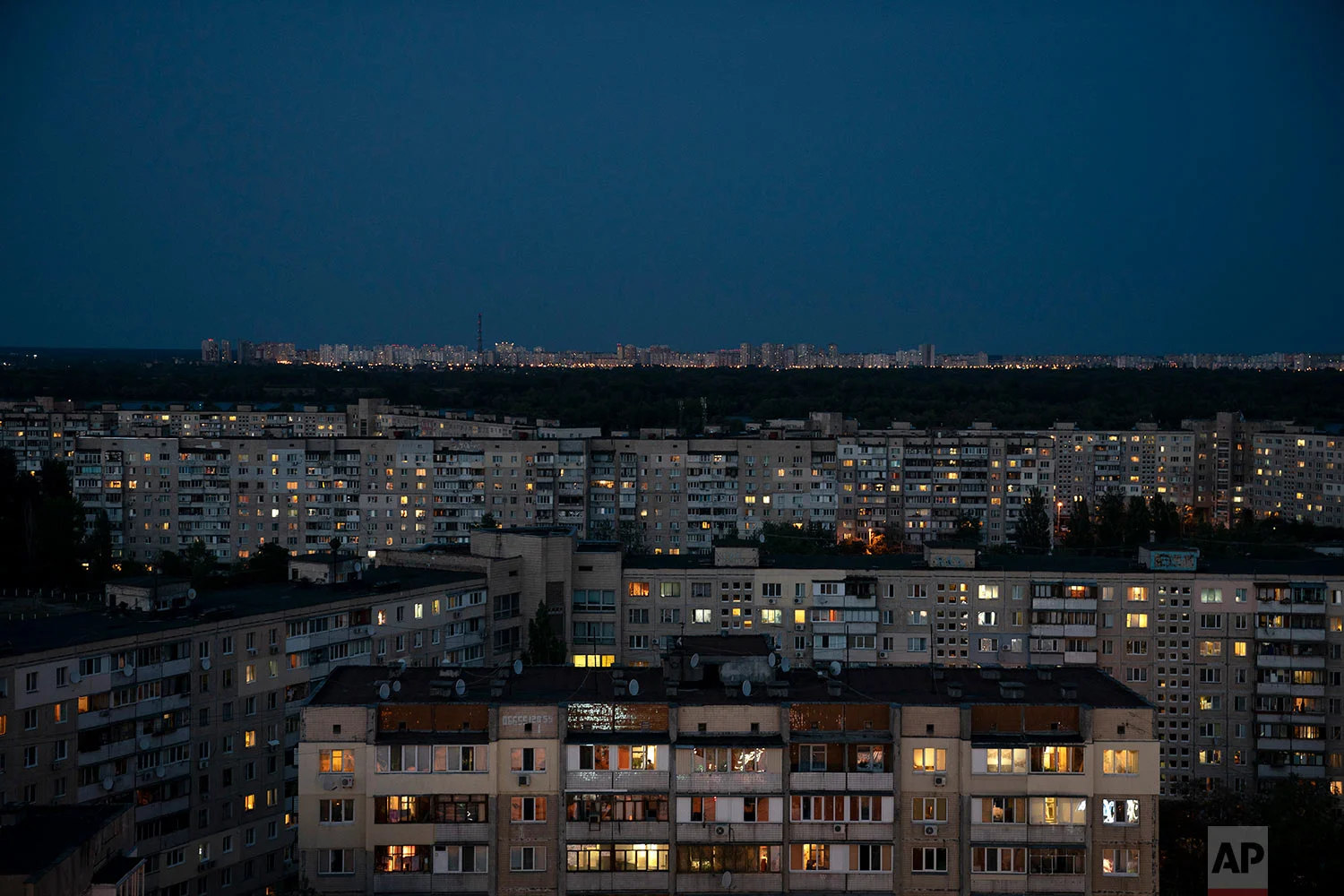 Buildings are illuminated at dusk In Kiev, Ukraine on Aug. 21, 2018. (AP Photo/Felipe Dana)