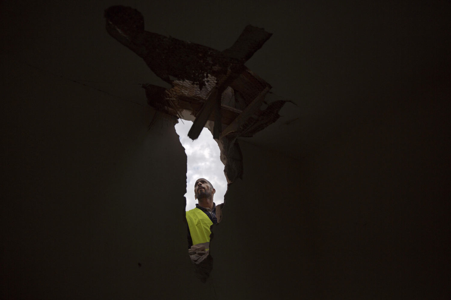 A man examines damage to a house after it was hit by a rocket on Monday in Sderot, southern Israel, Tuesday, March 26, 2019. Israel and Gaza's Hamas militants traded fire overnight after a rocket attack from Gaza struck a home in central Israel Monday. (AP Photo/Ariel Schalit)