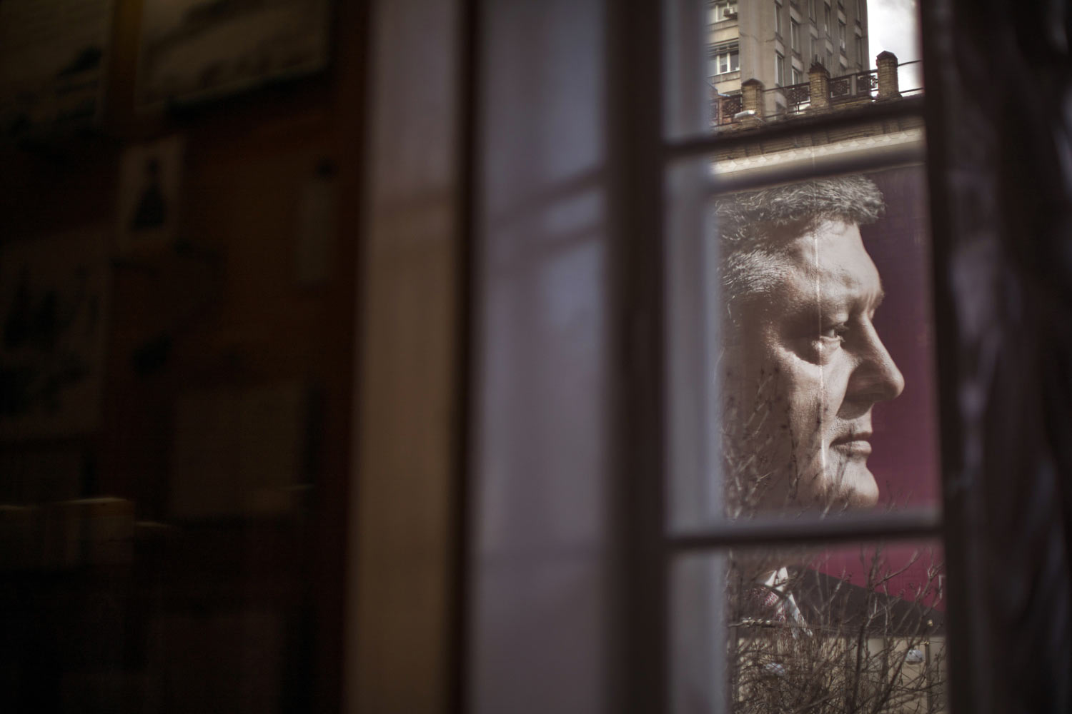  A large billboard with the face of Petro Poroshenko, president of Ukraine and candidate for 2019 elections, is seen through a window in central Kiev, Ukraine, Tuesday, March 26, 2019. Presidential elections are scheduled for March 31. (AP Photo/Emil