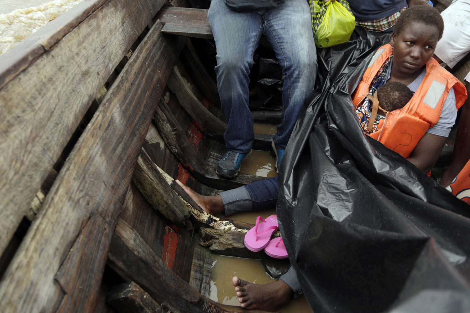 Veronica Fatia carries her 2-year-old daughter as they travel in a wooden boat to Buzi district, 200 kilometers (120 miles) outside Beira, Mozambique, on Saturday, March 23, 2019. They left the cyclone-shattered city of Beira for the town of Buzi, which for a week people had been fleeing to with little but their clothes. (AP Photo/Themba Hadebe)