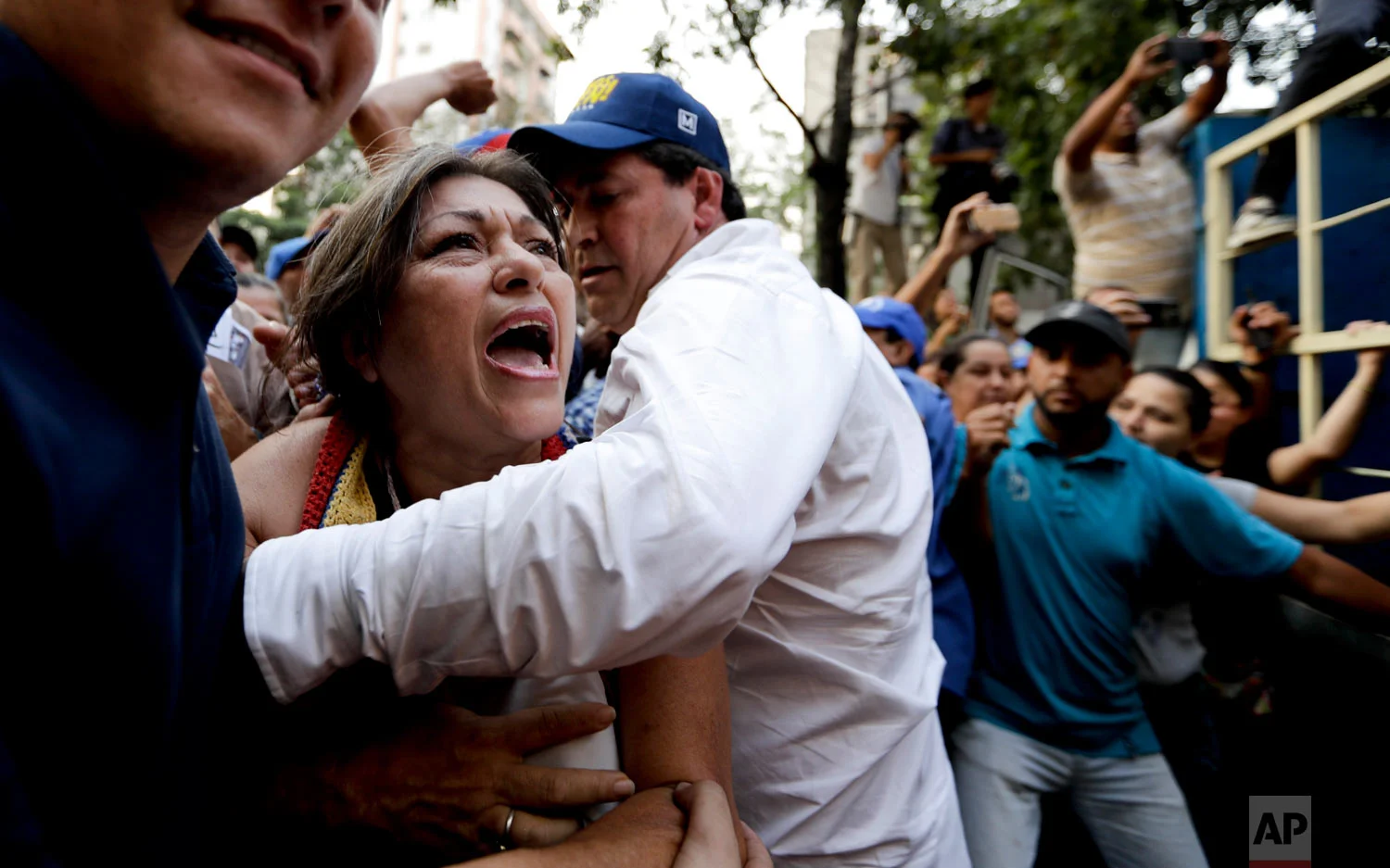 In this March 28, 2019 photo, a supporter of Venezuela's self-proclaimed interim president Juan Guaido is stopped as she tries to get near him during a rally in Caracas, Venezuela. (AP Photo/Natacha Pisarenko)