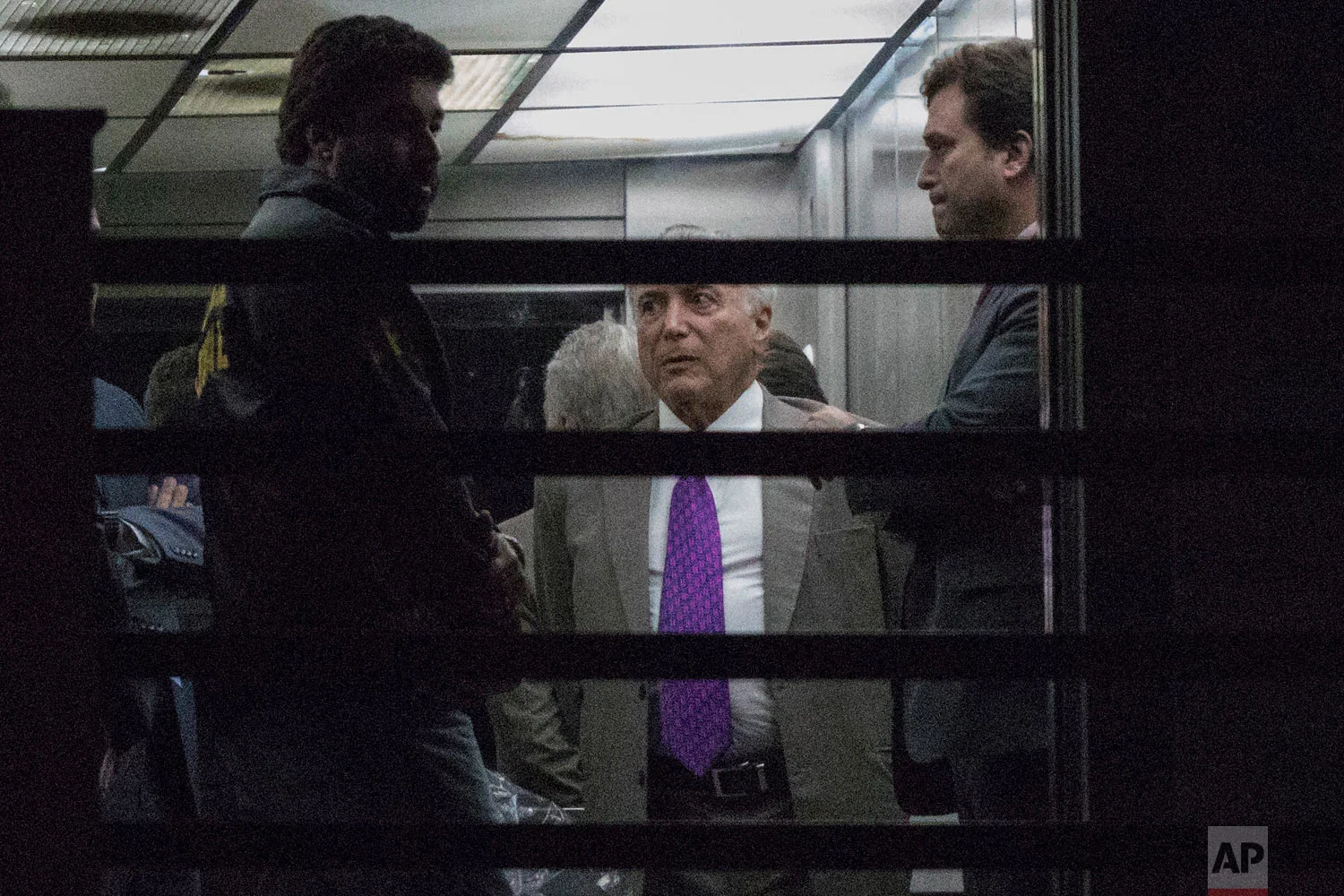 In this March 25, 2019 photo, former Brazilian President Michel Temer, second right, leaves the Federal Police headquarters in Rio de Janeiro, Brazil. (AP Photo/Leo Correa)