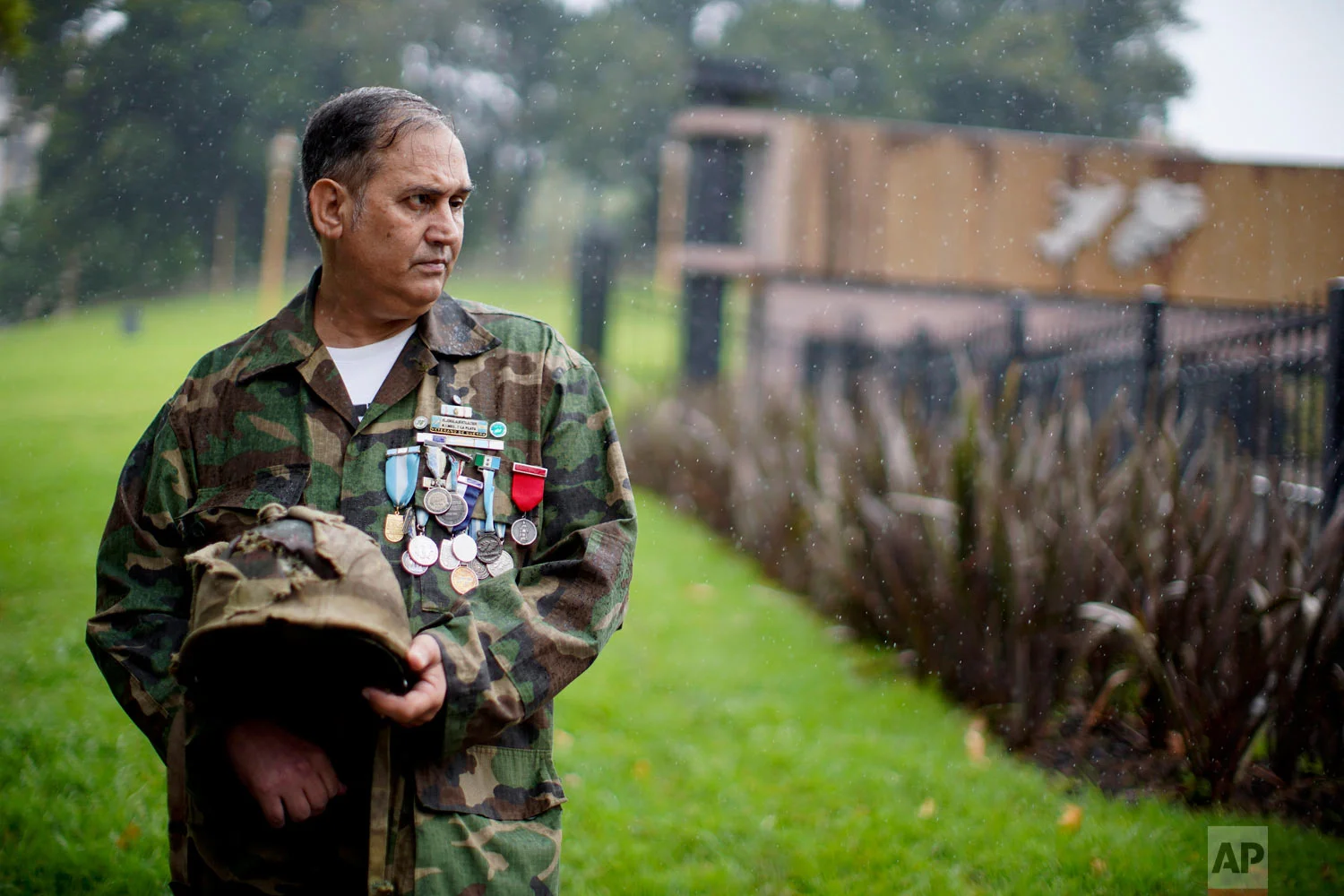 In this March 12, 2019 photo, Argentine war veteran Jorge Altieri poses for a portrait with the blood-stained helmet that saved his life in 1982 during the Falklands war, in Buenos Aires, Argentina. (AP Photo/Natacha Pisarenko)