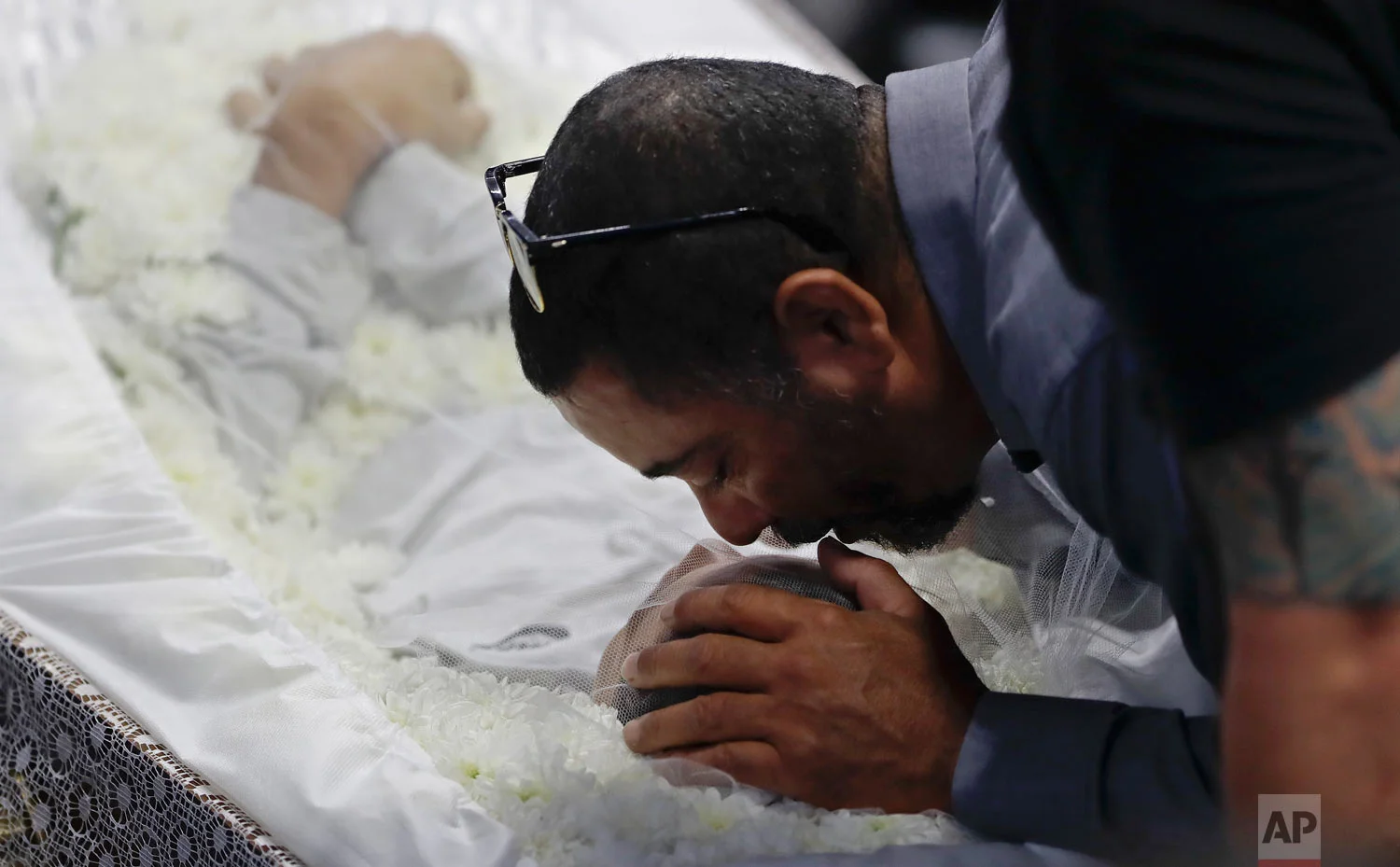 In this March 14, 2019 photo, a relative mourns Caio Oliveira, victim of the shooting at the Raul Brasil State School during a collective wake of the victims in Suzano, greater Sao Paulo area, Brazil. (AP Photo/Andre Penner)