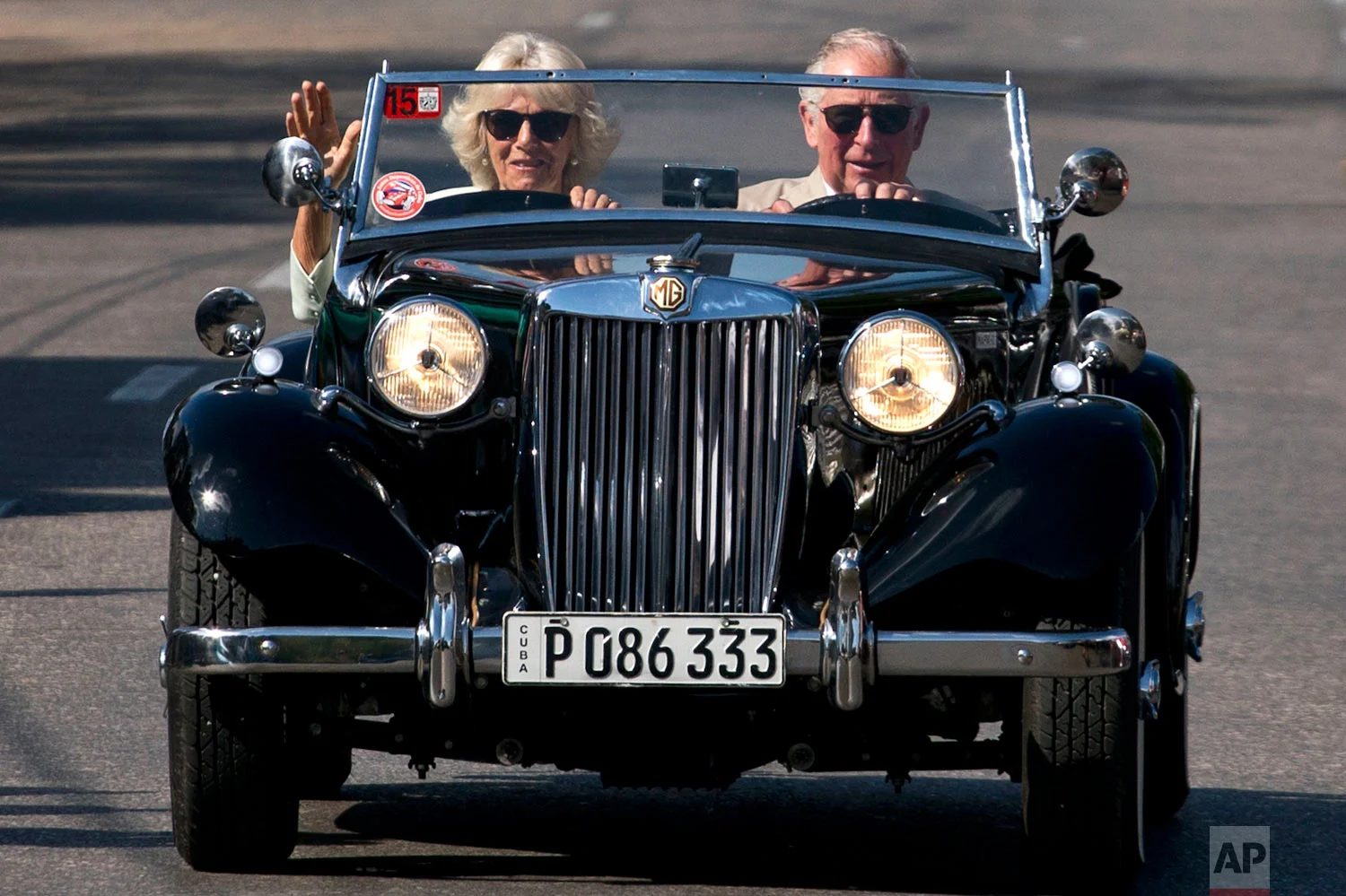 In this March 26, 2019 photo, Prince Charles drives a vintage car with his wife Camilla, Duchess of Cornwall, during a cultural event in Havana, Cuba. The heir to the British throne arrived in Cuba Sunday with an agenda including visits to historic sites, a solar park, organic farm, bio-medical research center, a meeting with entrepreneurs, a cultural gala and a dinner with Cuba's president. (AP Photo/Ramon Espinosa)
