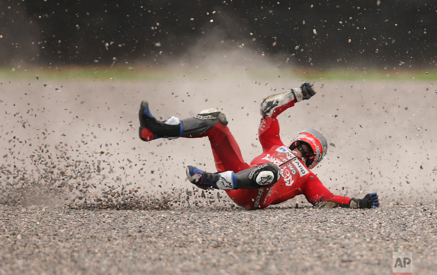 In this March 30, 2019 photo, Andrea Dovizioso of Italy falls from his bike during a Moto GP free practice run at the circuit in Termas de Rio Hondo, Argentina. Despite the fall Dovizioso raced in the third pole position on Sunday. (AP Photo/Nicolas Aguilera)