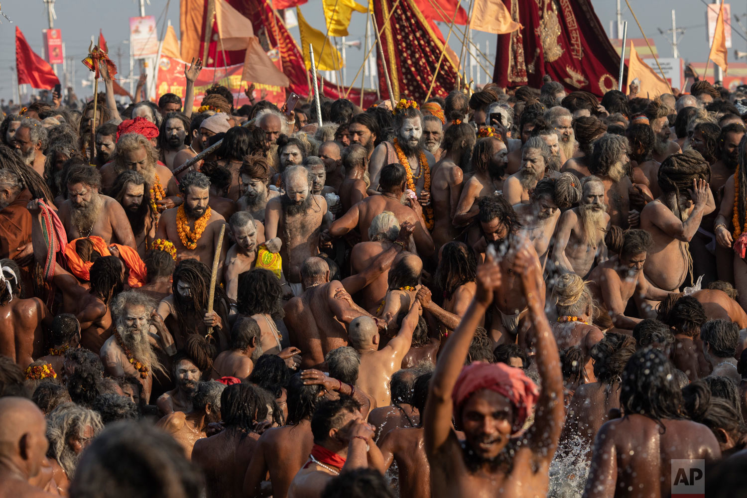 Hindu holy men, take a holy dip at Sangam, the confluence of the rivers Ganges, Yamuna and mythical Saraswati, during the Kumbh Mela festival in Prayagraj, India, Jan. 15, 2019. (AP Photo/Bernat Armangue)