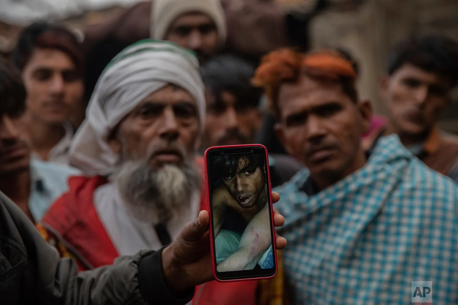 A man holds a phone showing a video of Muslim farmer Saghir Khan, 25, moments after being beaten, Mirzapur, India, Jan. 22, 2019. (AP Photo/Bernat Armangue)