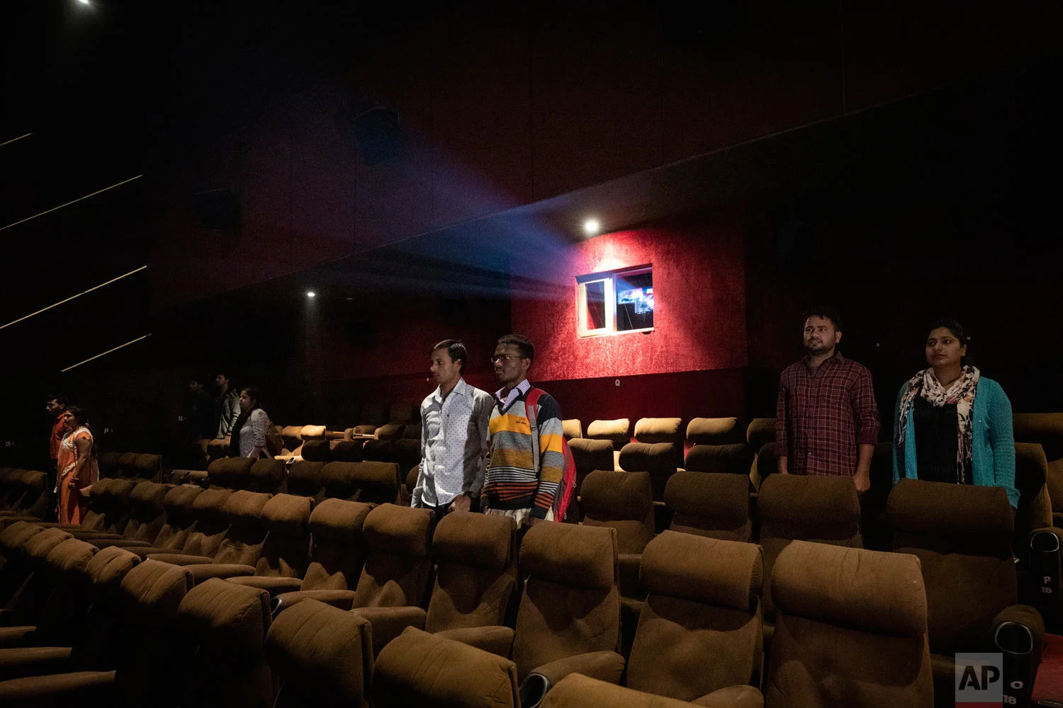 Moviegoers stand as national anthem is played at a cinema before the screening of a movie in Lucknow, Uttar Pradesh, India, Nov. 26, 2018. (AP Photo/Bernat Armangue)
