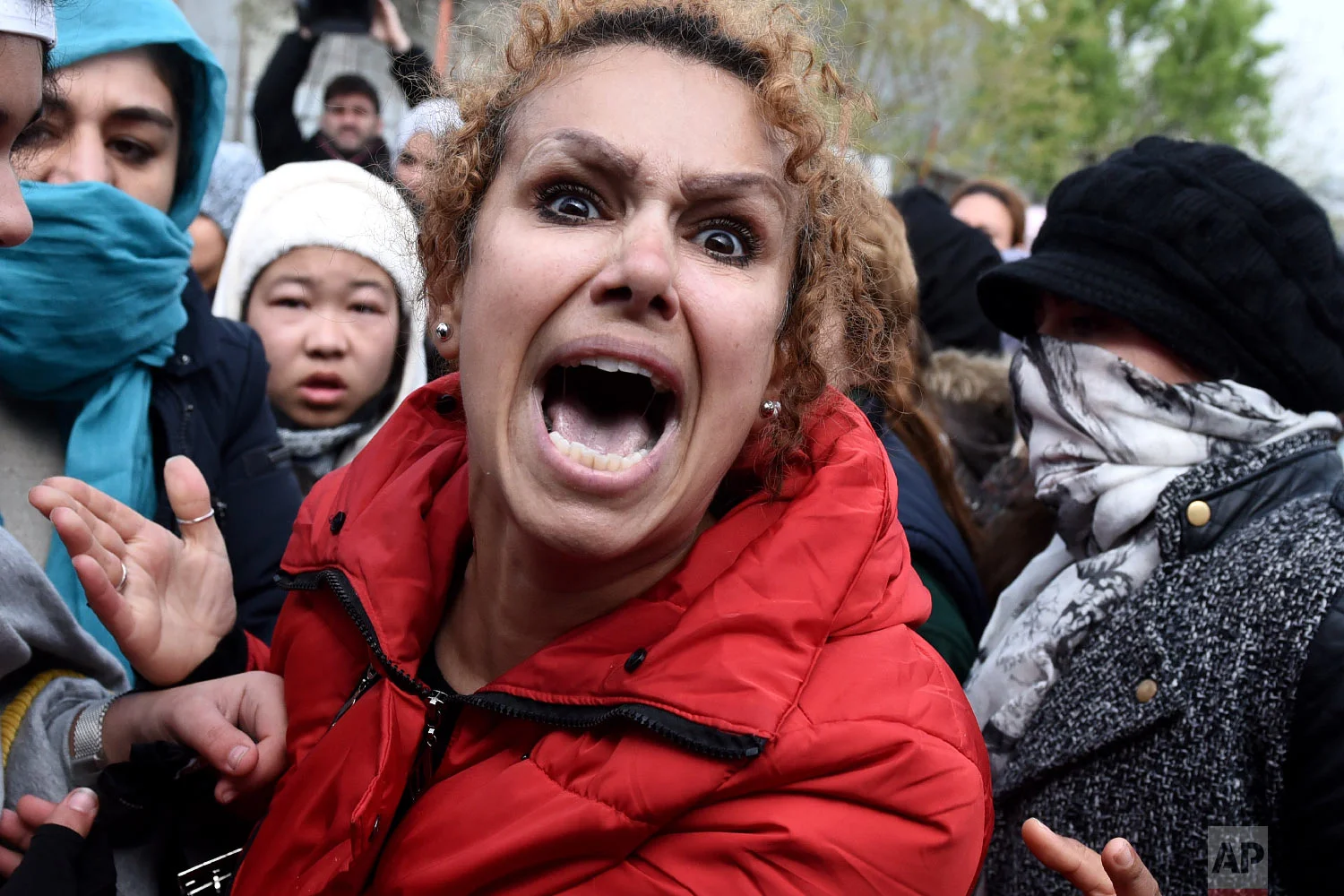 A migrant shouts during a protest outside a refugee camp in the village of Diavata, west of Thessaloniki, northern Greece, Friday, April 5, 2019. (AP Photo/Giannis Papanikos)