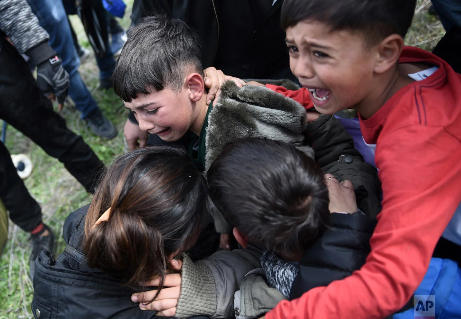 Children cry after police used tear gas during clashes outside a refugee camp in the village of Diavata, west of Thessaloniki, northern Greece, Friday, April 5, 2019. (AP Photo/Giannis Papanikos)