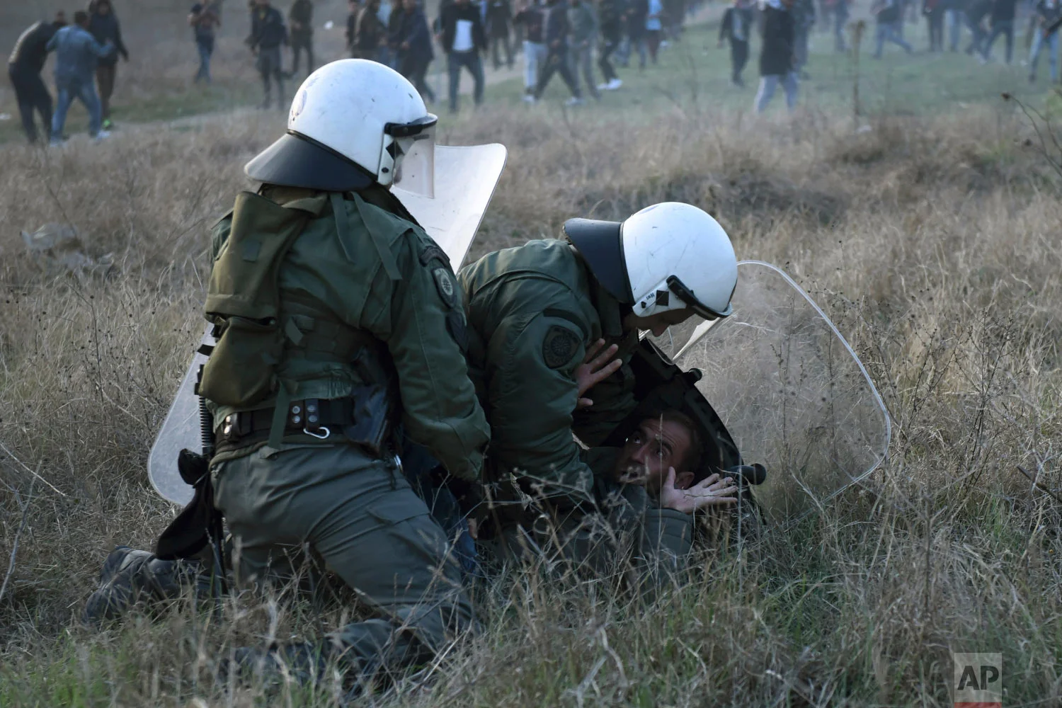 Riot police detain a protesting migrant during a rally outside a refugee camp in the village of Diavata, west of Thessaloniki, northern Greece, Thursday, April 4, 2019. (AP Photo/Giannis Papanikos)