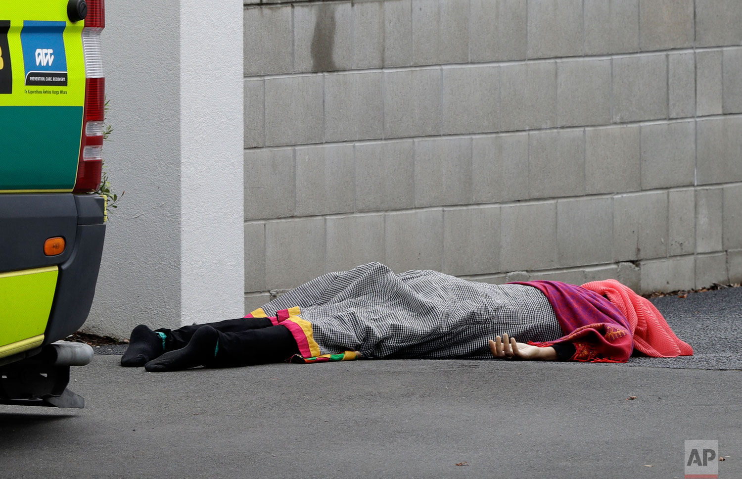 A body lies on the footpath outside a mosque in central Christchurch, New Zealand, Friday, March 15, 2019. (AP Photo/Mark Baker)
