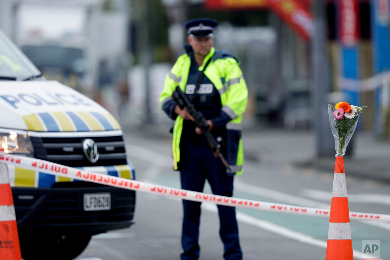  Flower rest at a road block, as a Police officer stands guard near the Linwood mosque, site of one of the mass shootings at two mosques in Christchurch, New Zealand, Saturday, March 16, 2019. (AP Photo/Mark Baker) 