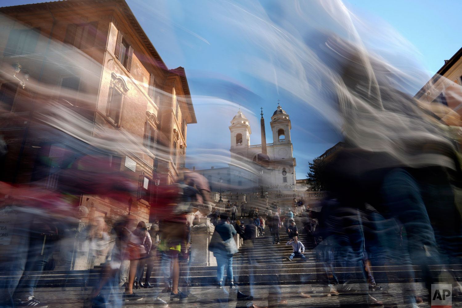 In this photo made with a long exposure, people walk by the Spanish Steps in Rome, Monday, March 25, 2019. (AP Photo/Andrew Medichini)