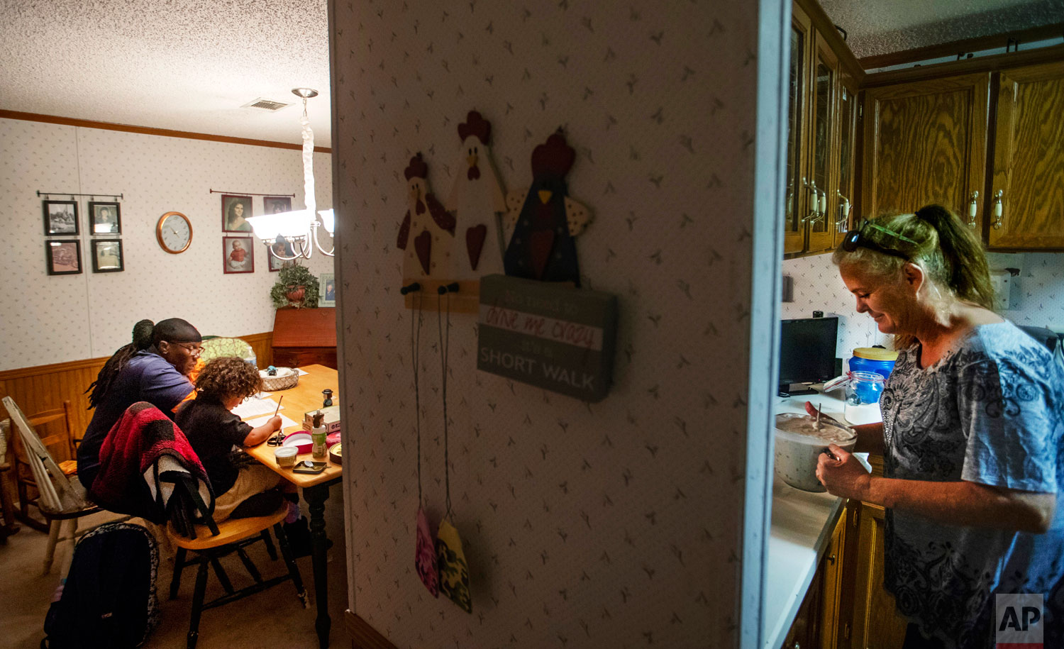  Diahnn "Shelly" Summers, right, prepares dinner for local residents left homeless by Hurricane Michael who are living in tents in her backyard as Jacinta Wheeler, left, who is one of those left homeless, helps Summers' daughter, Gabby, 7, with her h