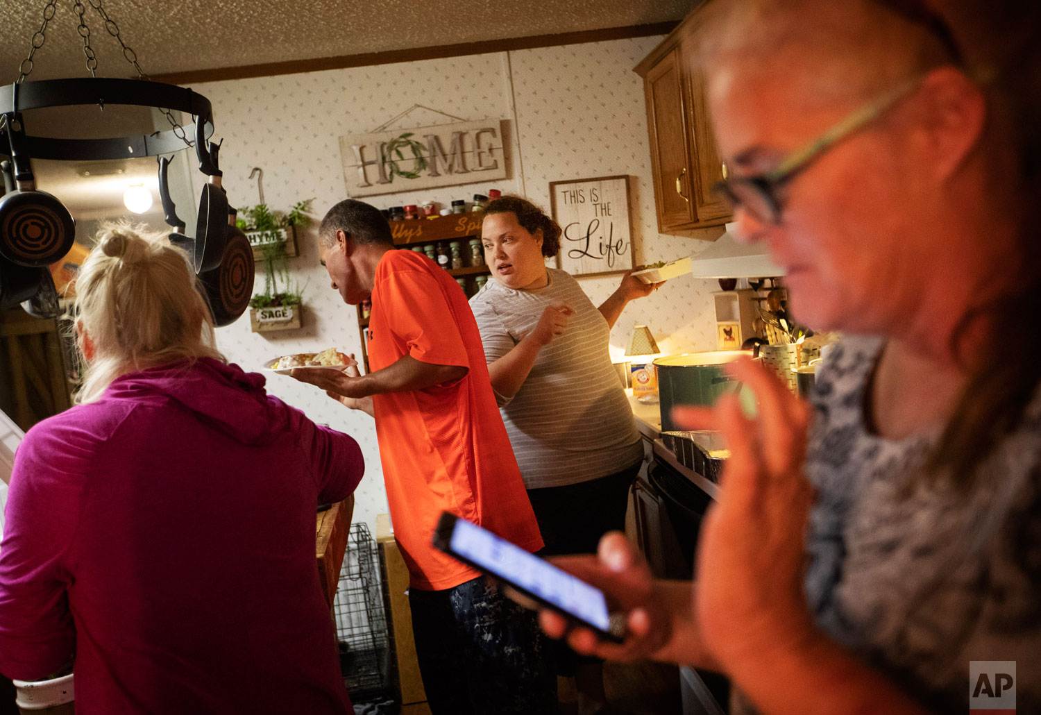  Mystie Gregory, rear right, serves herself dinner with fellow local residents left homeless by Hurricane Michael who are living in tents in the backyard of Diahnn "Shelly" Summers, right, in Youngstown, Fla, Wednesday, Jan. 23, 2019. Summers tries t