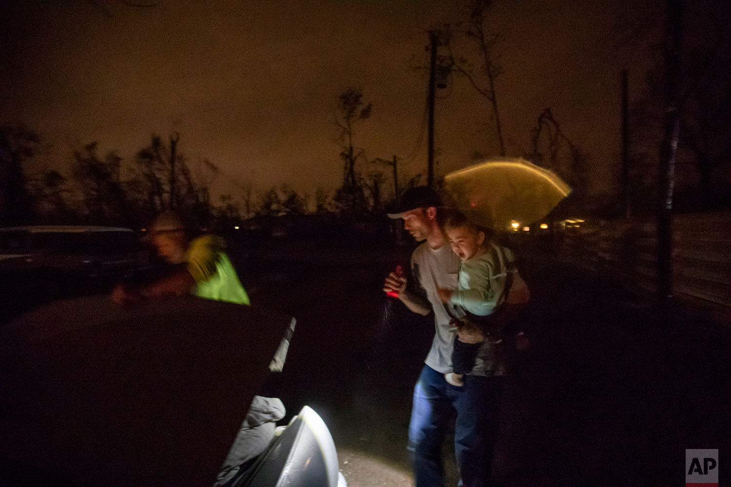 Twenty-month-old Neala Clark cries as her mother's fiancé, Gary LaPlant, loads their personal belongings from the tent they're living in into a car taking them to a halfway home LaPlant found for them in the middle of a rain storm in Youngstown, Fla, Wednesday, Jan. 23, 2019. After the family spent the night at the halfway home, they planned to return the next day to live in their tent in the Summer's backyard where they feel more comfortable. "It's such a positive environment out there despite the mess everyone had gone through," said LaPlant's fiancee, Mystie Gregory. (AP Photo/David Goldman)