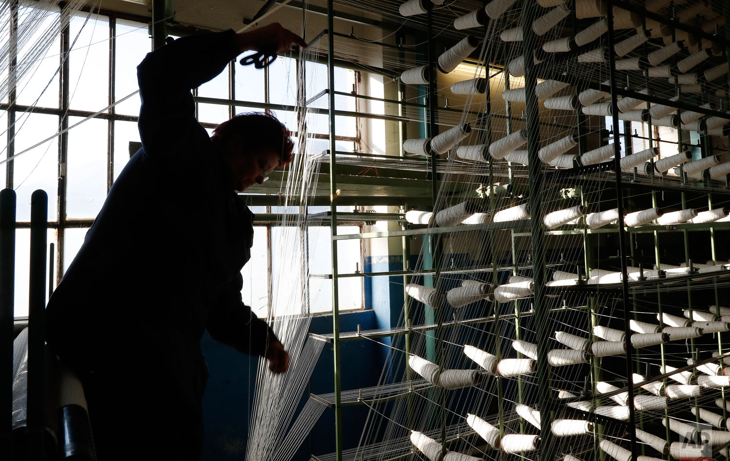  In this photo taken on Wednesday, Feb. 6, 2019, a woman works at "La Rete" (The Net) factory in Monte Isola, Lake Iseo, northern Italy. Step off the ferry onto Monte Isola and it feels like going back in time. The factory of La Rete S.r.l. , an old-