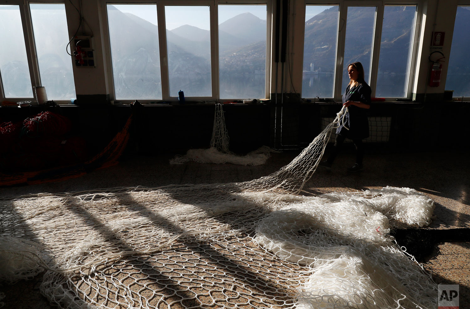 In this photo taken on Wednesday, Feb. 6, 2019, a woman works at "La Rete" (The Net) factory in Monte Isola, Lake Iseo, northern Italy. (AP Photo/Antonio Calanni)