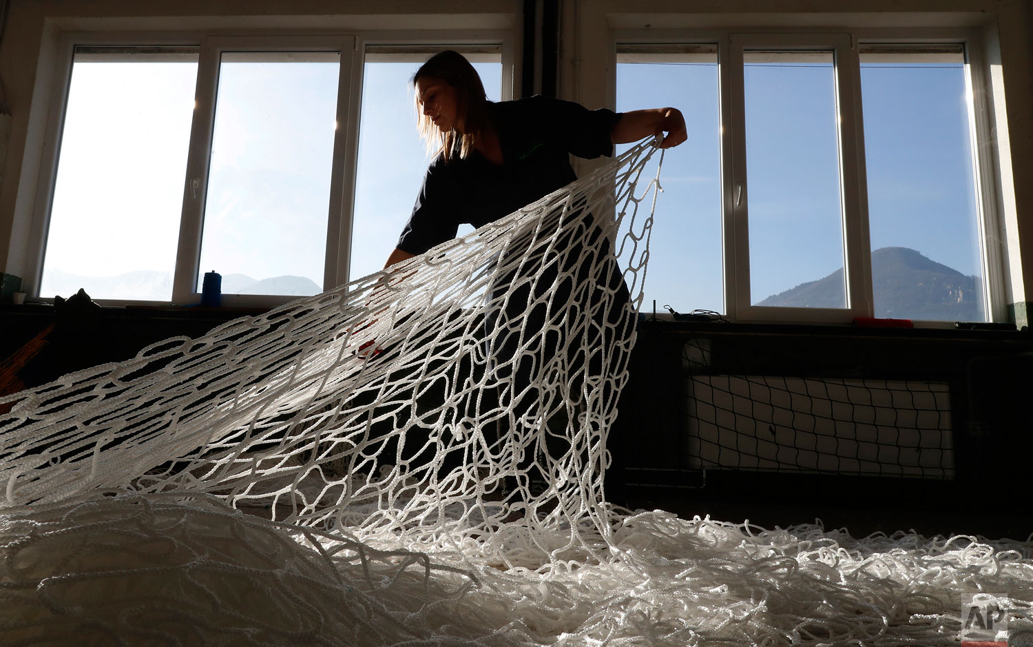  In this photo taken on Wednesday, Feb. 6, 2019, a woman works at "La Rete" (The Net) factory in Monte Isola, Lake Iseo, northern Italy.  (AP Photo/Antonio Calanni) 