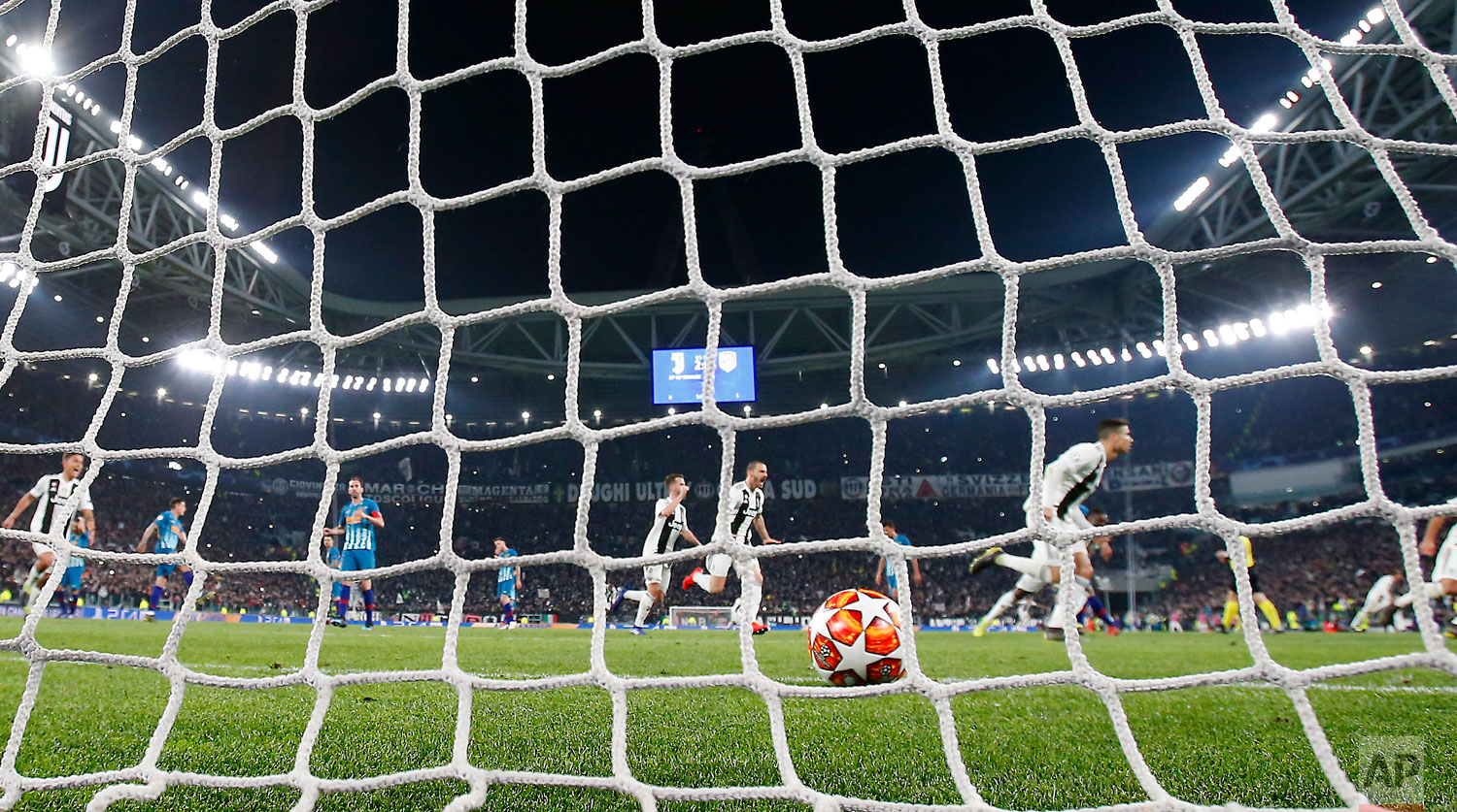  In this photo taken on Tuesday, March 12, 2019 through a net made by "La Rete" factory,  Juventus' Cristiano Ronaldo celebrates after scoring his side's third goal during the Champions League round of 16, 2nd leg, soccer match between Juventus and A