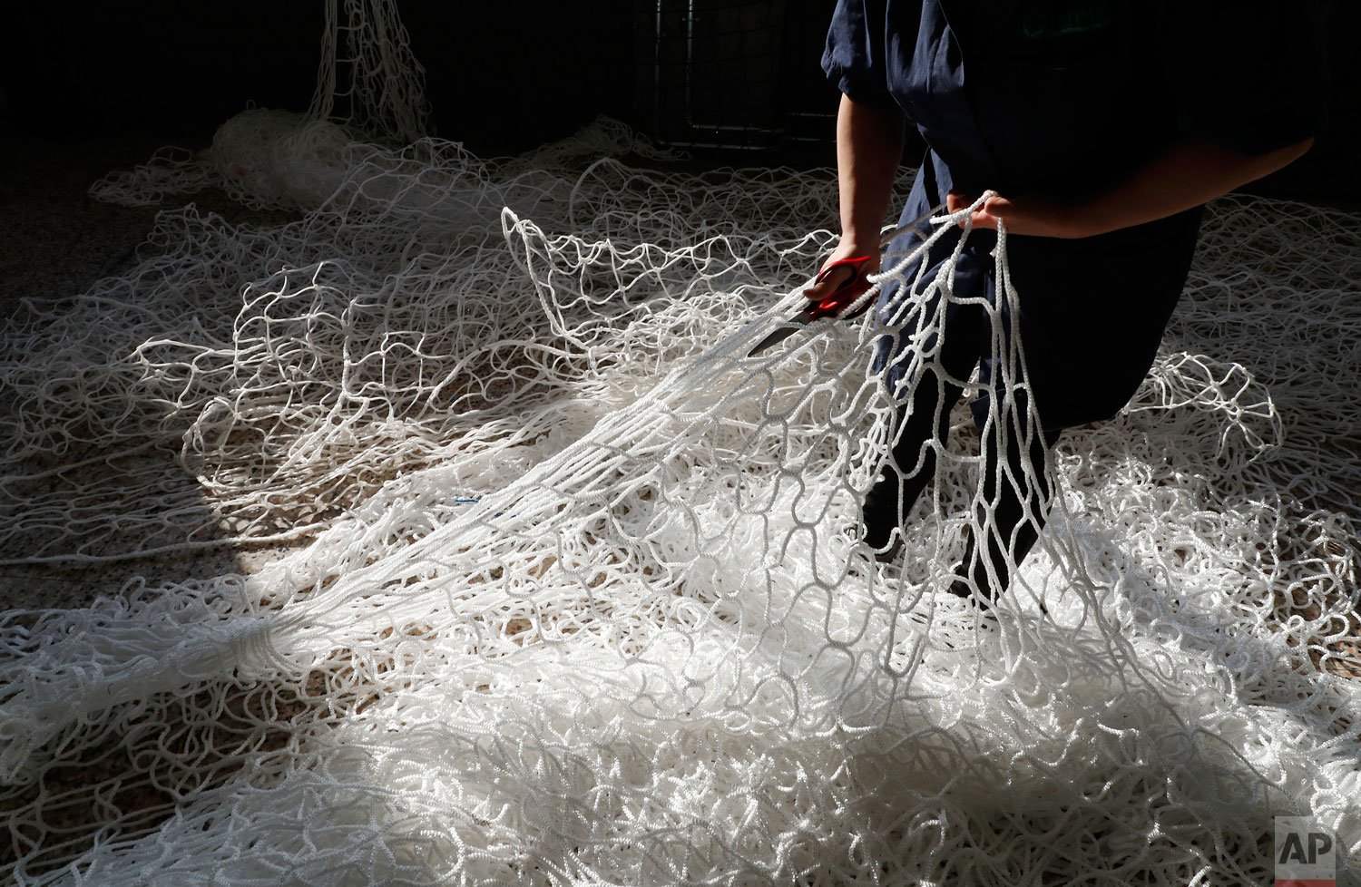 In this photo taken on Wednesday, Feb. 6, 2019, a woman works at "La Rete" (The Net) factory in Monte Isola, Lake Iseo, northern Italy. (AP Photo/Antonio Calanni)