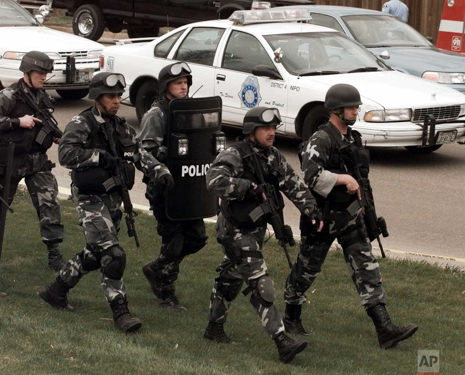  In this April 20, 1999 photo, members of a police SWAT march to Columbine High School in Littleton, Colo., as they prepare to do a final search of the school. Twelve students and a teacher died in the shootings before two teenage gunmen committed su