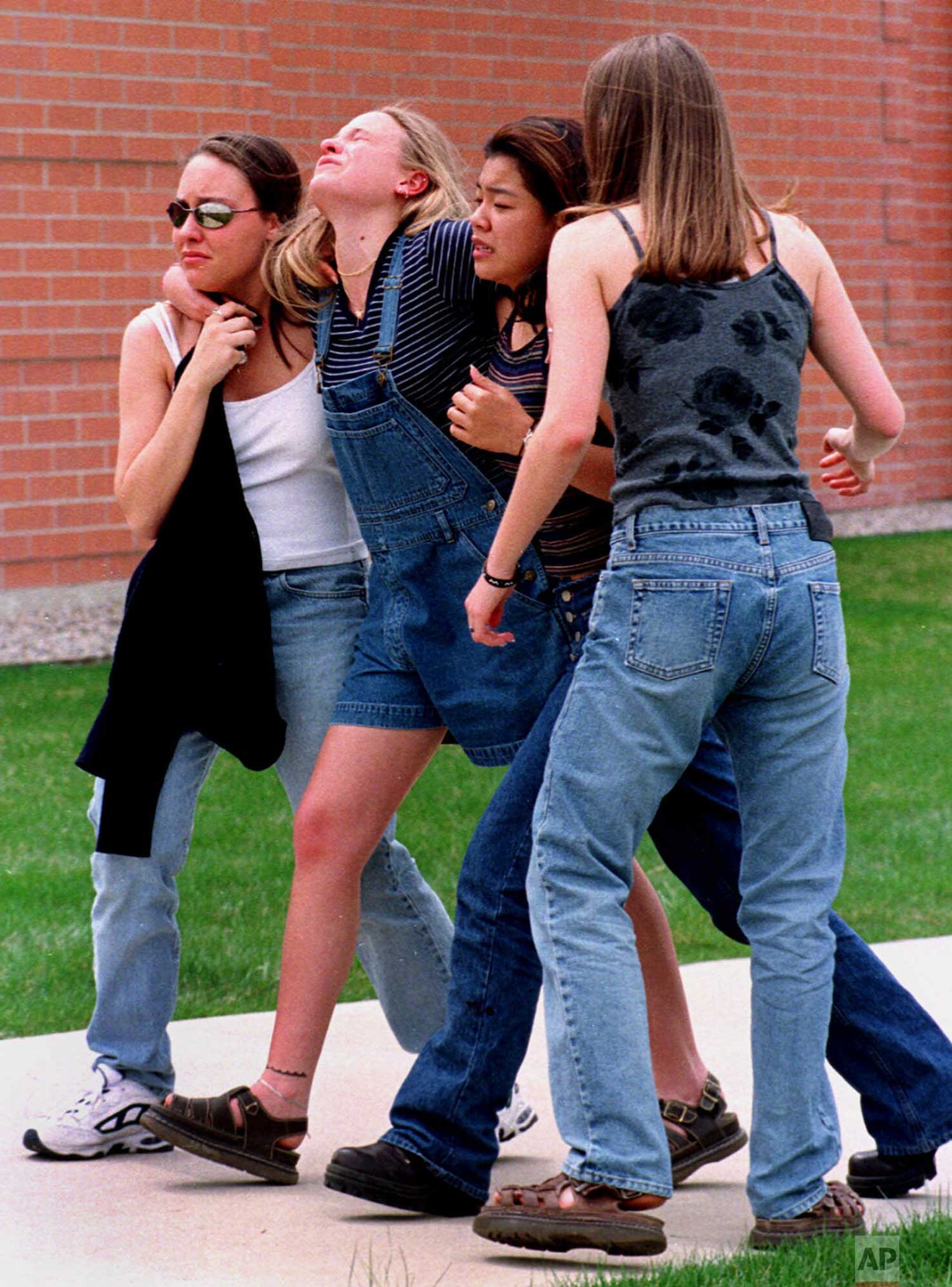  Unidentified young women head to a library near Columbine High School where students and faculty members were evacuated after two gunmen went on a shooting rampage in the school in the southwest Denver suburb of Littleton, Colo., Tuesday, April 20, 