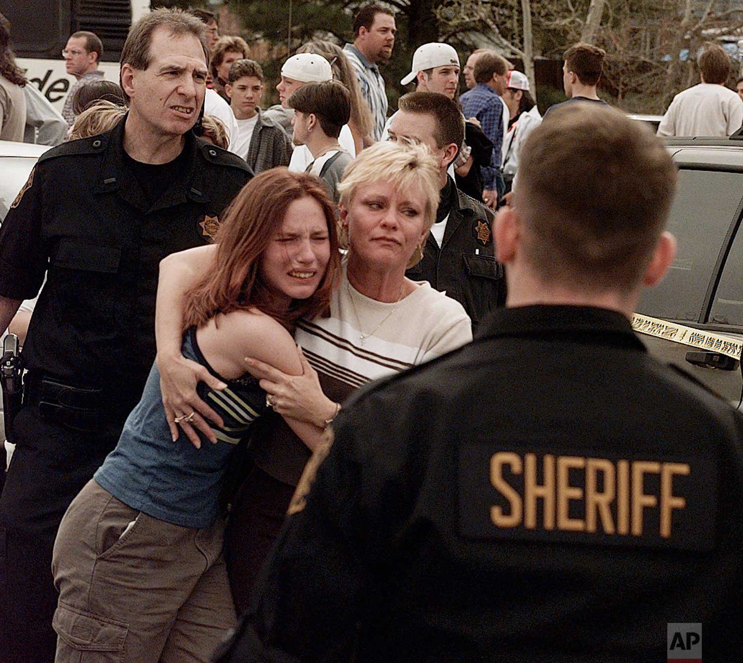  A woman embraces her daughter after they were reunited following a shooting at Columbine High School in Littleton, Colo., on Tuesday, April, 20, 1999. (AP Photo/Ed Andrieski) 