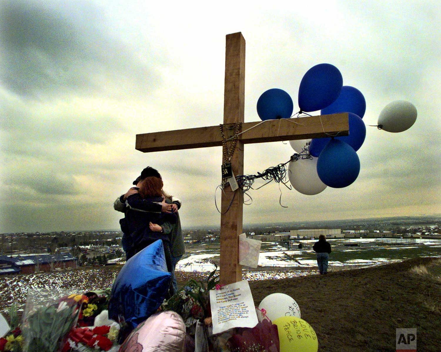  Unidentified students embrace each other at a makeshift memorial for their slain classmates at Columbine High School on a hilltop overlooking the school in Littleton, Colo, Saturday April 24, 1999. Twelve students and a teacher were killed in a murd