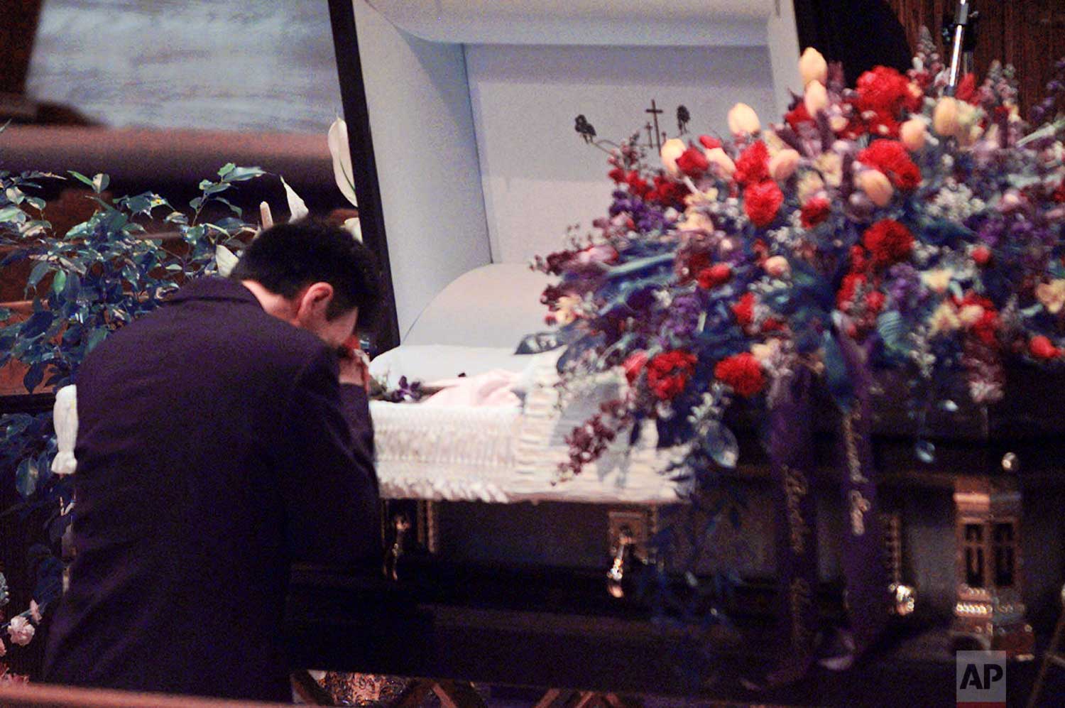  An unidentified mourner pauses to pray in front of the casket of Kyle Velasquez during funeral services in Littleton, Colo., Tuesday, April 27, 1999. Velasquez was killed during a shooting rampage at Columbine High School. (AP Photo/Laura Rauch) 
