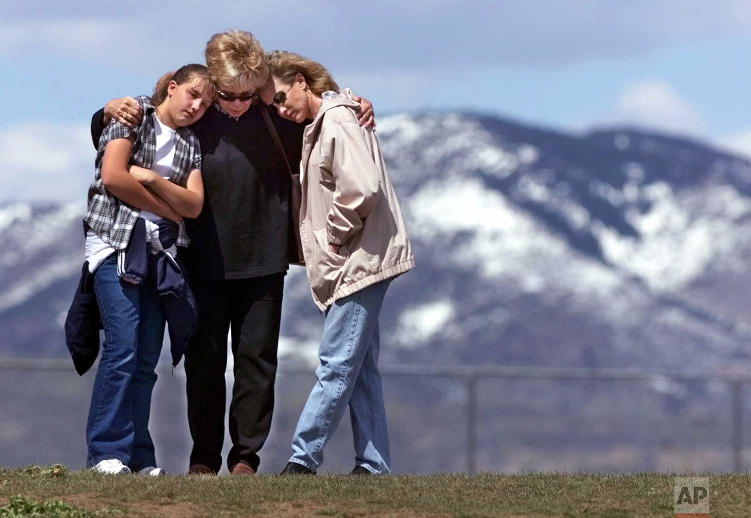  Standing on a hill above Columbine High School in Littleton, Colo., Krista Sleeth, Bev Fleer, and Cindy Sleeth hug during a moment of silence Tuesday, April 27, 1999 for the victims of the shooting spree at school. Krista, Bev and Cindy are three ge