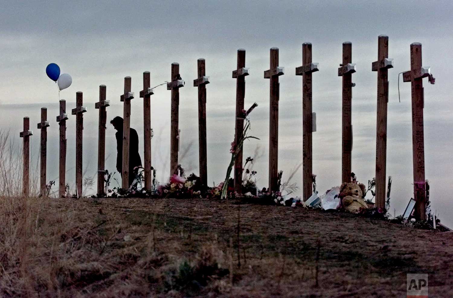  An unidentified woman looks at 15 crosses posted on a hill above Columbine High School in Littleton, Colo. Wednesday, April 28, 1999 in remembrance of the 15 people who died during a shooting rampage at the school. (AP Photo/Eric Gay) 