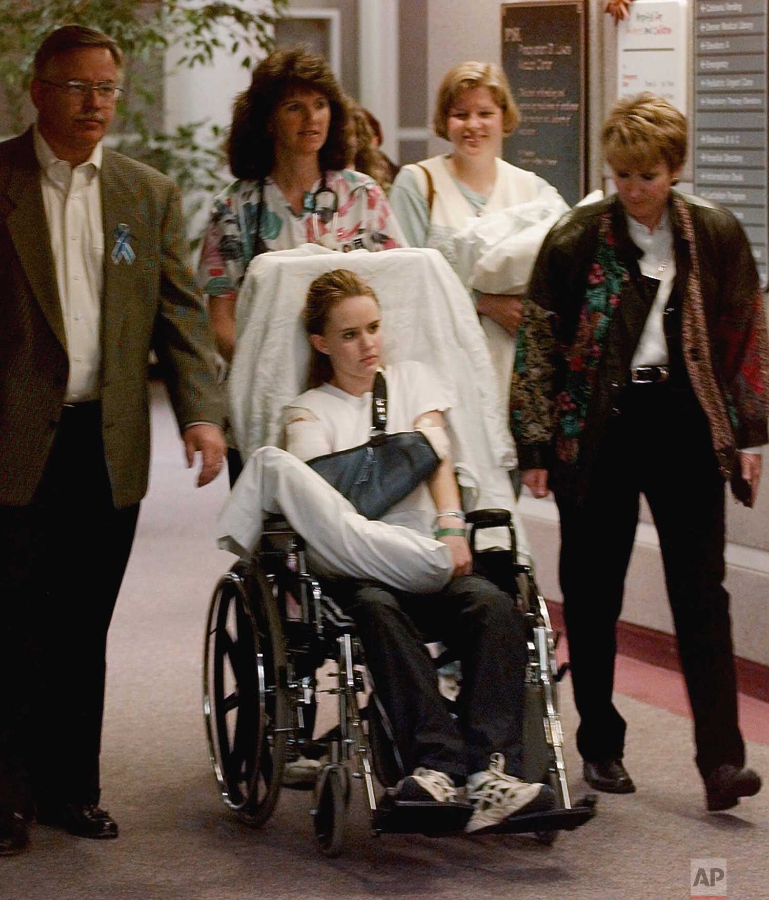  Kacey Ruegsegger, 17, is wheeled from a Denver hospital by Patty Anderson, center, after being released on Saturday, May 1, 1999. Walking beside her are her parents Greg, left, and Darcy, right. Kacey was shot in the shoulder during the shooting ram