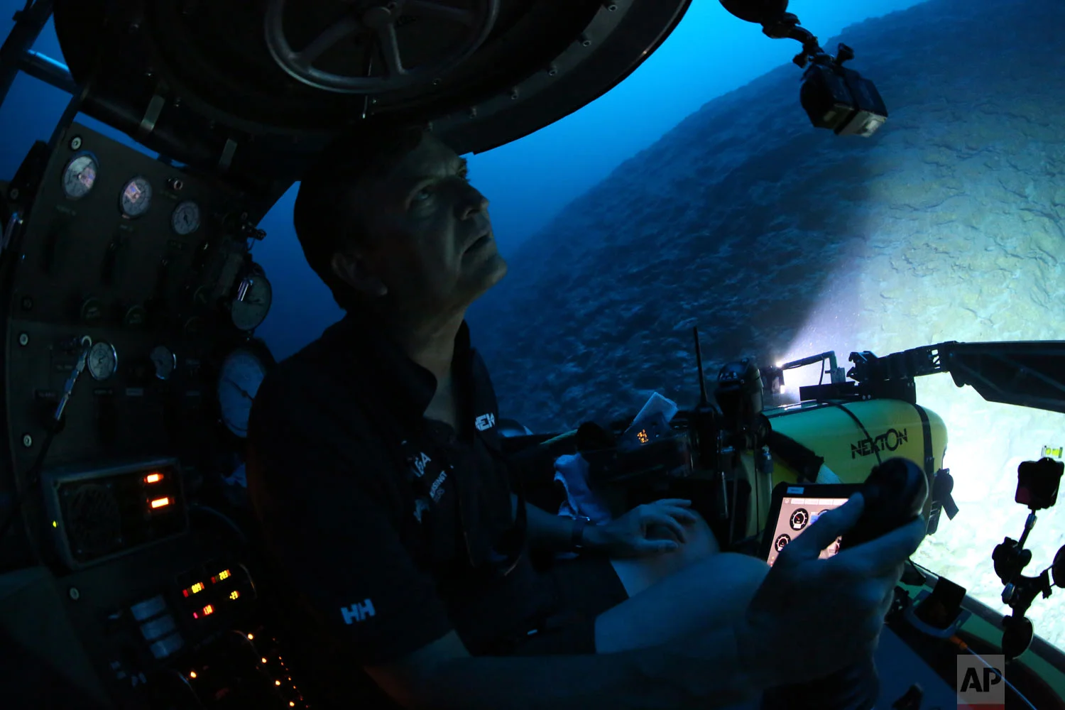 Aquanaut Robert Carmichael looks out of the submersible as he navigates strong currents during a dive to 400 feet below the surface on April 8, 2019. (AP Photo/David Keyton)