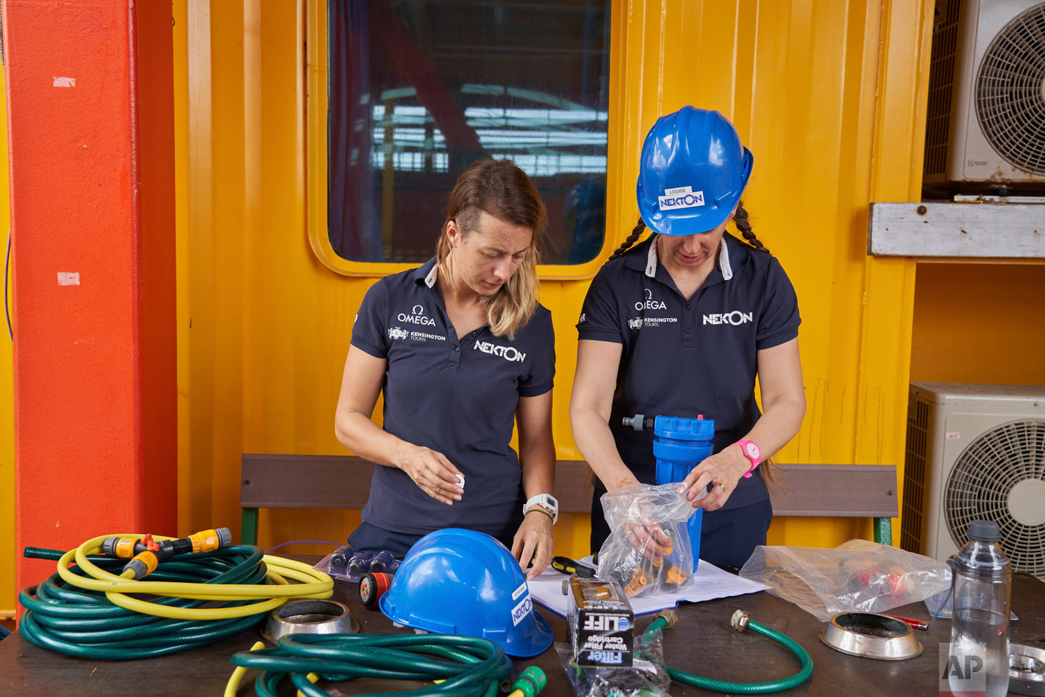 Researchers Roxana Walton, left, and Louise Allcock prepare equipment ahead the first science tasks of the British-led Nekton Mission in the tiny atoll of Alphonse in Seychelles waters, March 7, 2019. (AP Photo/David Keyton)
