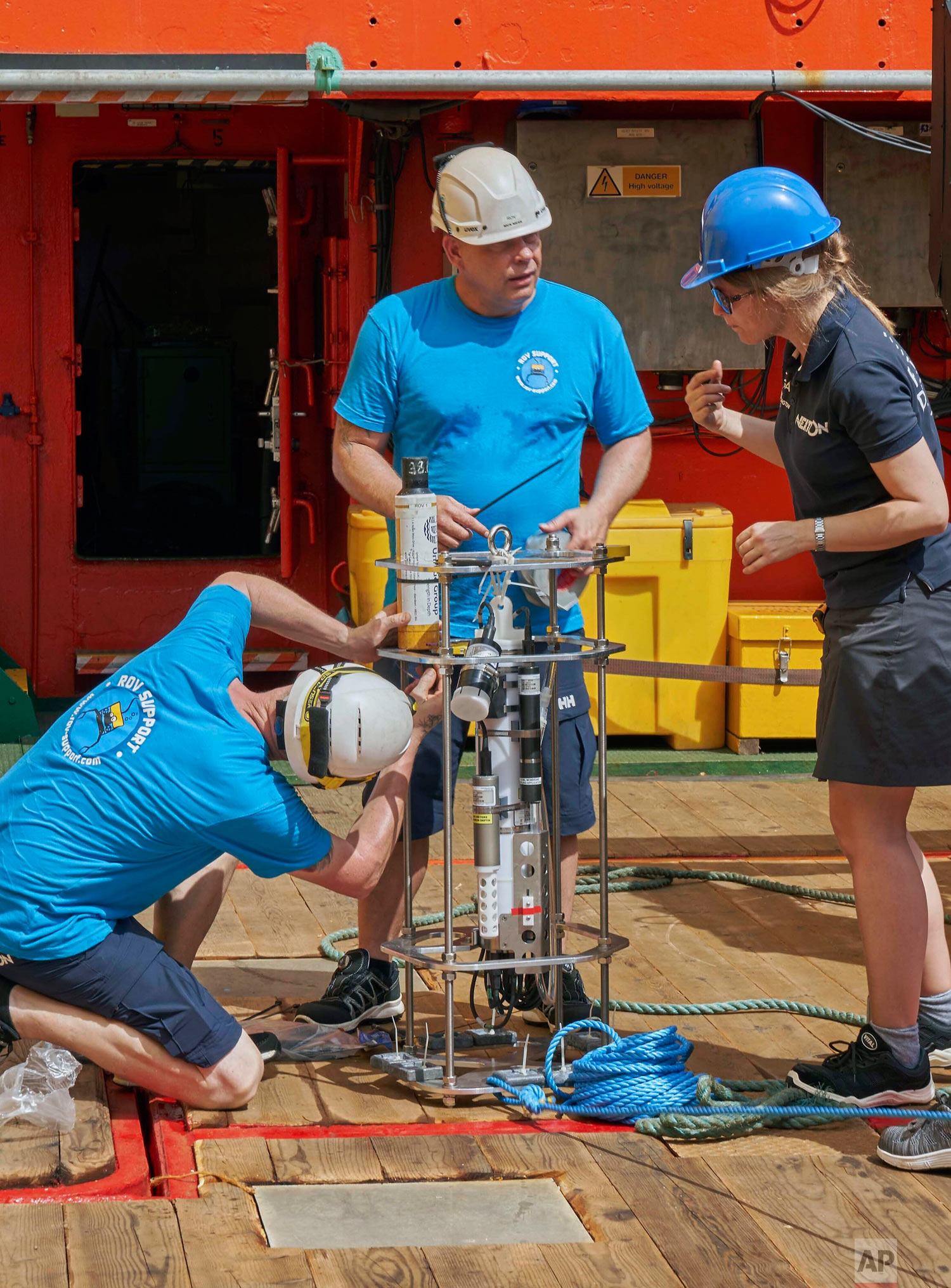Researchers prepare a water measurement device, called CTD, as the British-led Nekton Mission begins preparations in the Indian Ocean, March 7, 2019. (AP Photo/David Keyton)