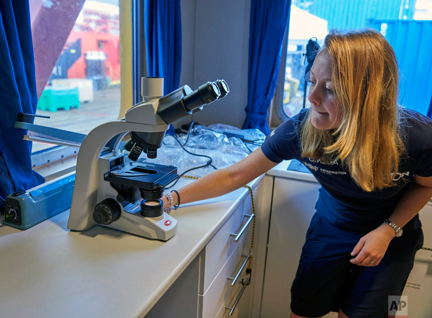 Oxford University researcher, Denise Swanborn, tests a microscope in a laboratory onboard the Ocean Zephyr, the mothership of the British-based Nekton Mission on March 5, 2019. (AP Photo/David Keyton)
