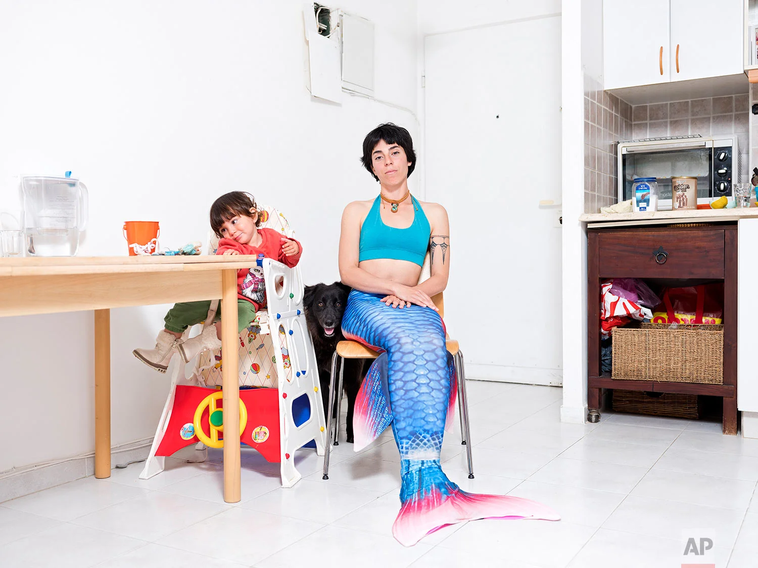 In this Tuesday, Feb. 26, 2019 photo, Ommer Globerman, a member of the Israeli Mermaid Community, poses for a portrait as she wears a mermaid tail at her home in Ashkelon, Israel. (AP Photo/Oded Balilty)