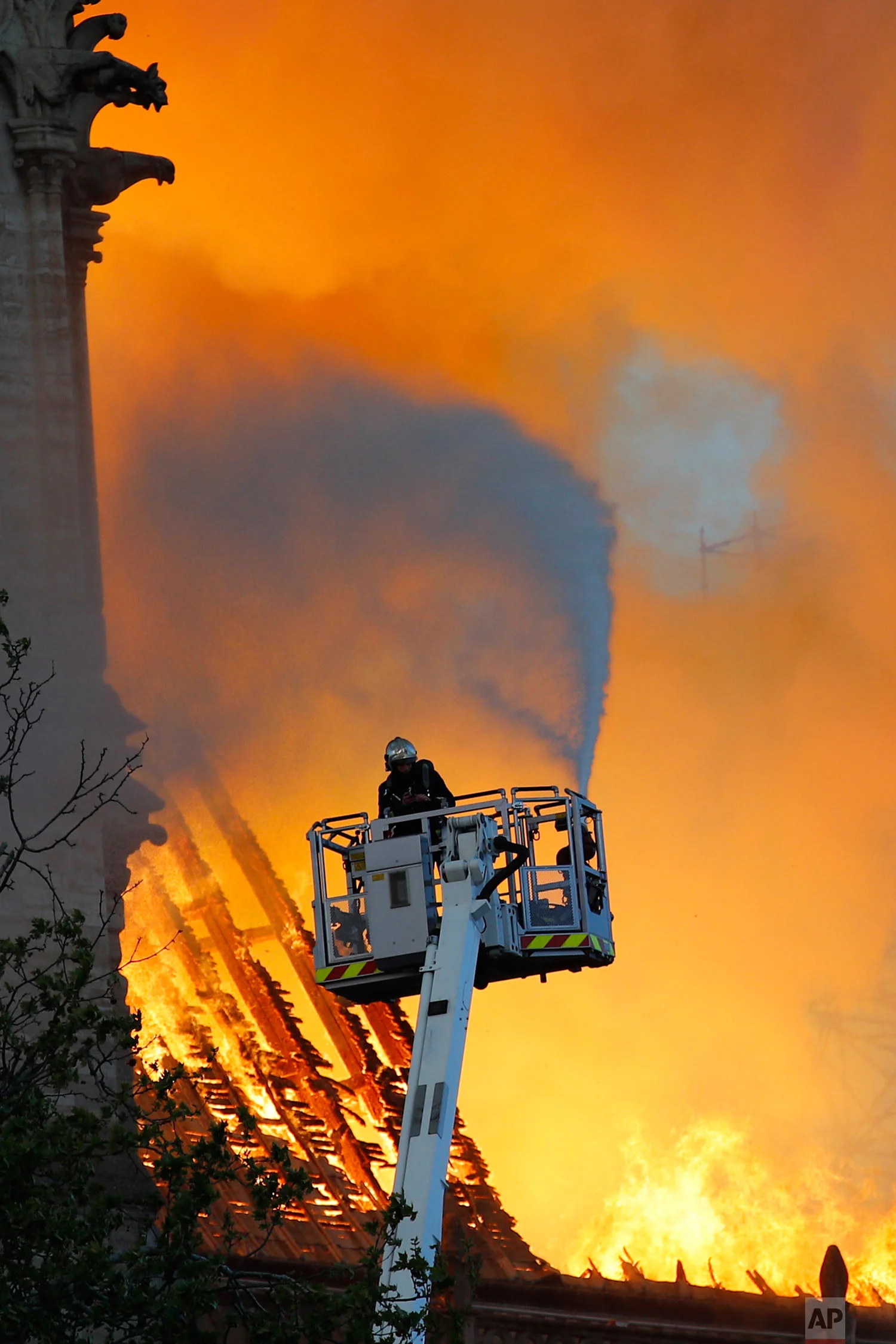 A firefighter uses a hose as Notre Dame Cathedral burns in Paris, April 15, 2019. (AP Photo/Francois Mori)