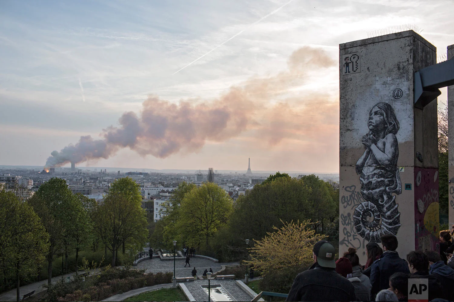 People watch Notre Dame Cathedral burn in Paris, Monday, April 15, 2019. (AP Photo/Rafael Yaghobzadeh)