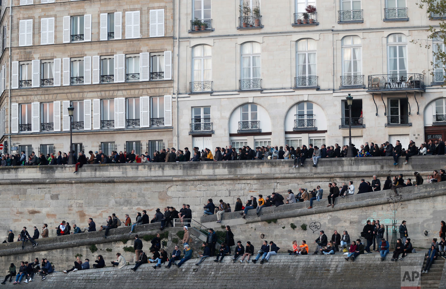 People watch as flames and smoke rise from the Notre Dame Cathedral as it burns in Paris, April 15, 2019. (AP Photo/Thibault Camus)