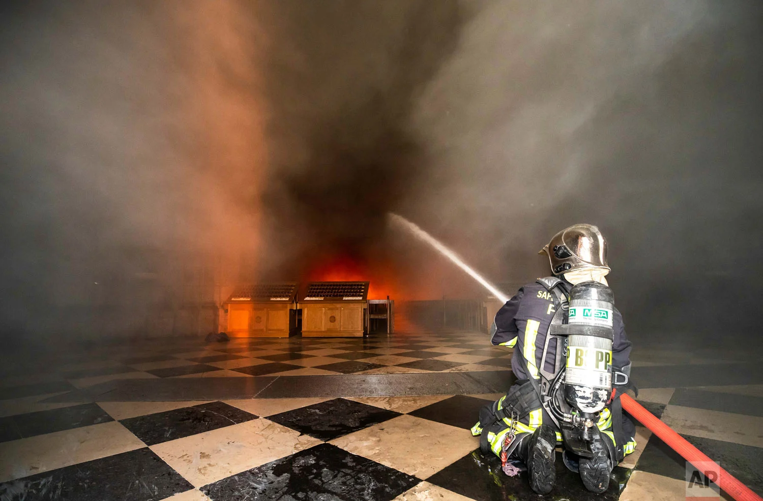 In this photo provided by the Paris Fire Brigade, firefighters spray water inside Notre Dame Cathedral, April 15, 2019. (Benoit Moser, BSPP via AP)